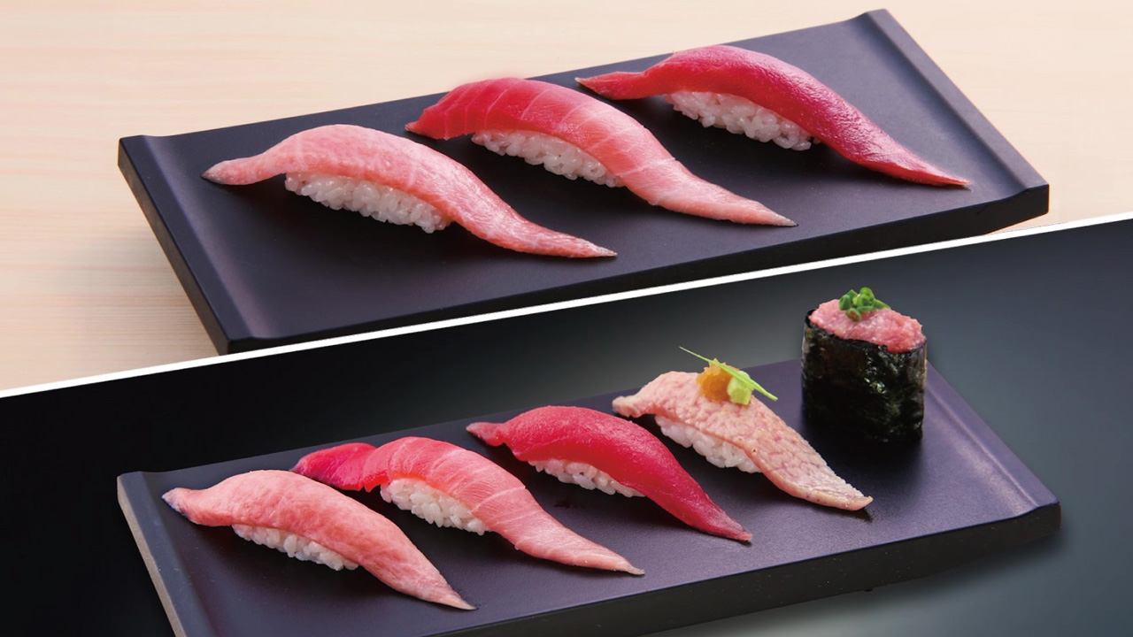 A variety of maguro tuna sushi on black plates.